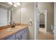 Bathroom vanity with granite countertops and undermount sink with a door leading to bedroom at 19719 Prince Benjamin Dr, Lutz, FL 33549
