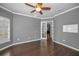 Bright bedroom with hardwood floors, ceiling fan, and natural light from the open doorway at 19719 Prince Benjamin Dr, Lutz, FL 33549
