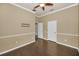 Open bedroom with hardwood floors, neutral colors, ceiling fan, and multiple doors at 19719 Prince Benjamin Dr, Lutz, FL 33549