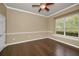 Neutral bedroom with hardwood floors, ceiling fan, and window with plenty of natural light at 19719 Prince Benjamin Dr, Lutz, FL 33549