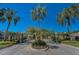 Community entrance with stone pillars, iron gate and mature palm tree landscaping on a sunny day at 19719 Prince Benjamin Dr, Lutz, FL 33549