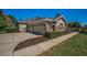 Three car garage with an attractive home exterior featuring stone accents and well-maintained landscaping at 19719 Prince Benjamin Dr, Lutz, FL 33549