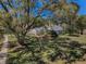 The home's facade is framed by mature trees, showing the architectural details and landscaping, with a nice blue sky at 19719 Prince Benjamin Dr, Lutz, FL 33549
