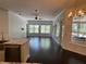 Living area with dark wood floors, multiple windows, and open-concept design to kitchen at 19719 Prince Benjamin Dr, Lutz, FL 33549