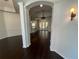 Open-concept design with dark wood floors, columned archways, and stylish light fixtures at 19719 Prince Benjamin Dr, Lutz, FL 33549
