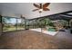 Spacious covered patio showcases brick pavers, ceiling fans, and picturesque views of the pool and lush landscaping at 19719 Prince Benjamin Dr, Lutz, FL 33549