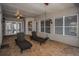 Covered outdoor patio with tile flooring, two chaise lounges, ceiling fan, and outdoor lighting at 19719 Prince Benjamin Dr, Lutz, FL 33549