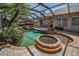 The screened-in pool area showcases the freeform pool, spa, and beautiful landscaping, creating a private oasis at 19719 Prince Benjamin Dr, Lutz, FL 33549