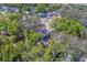 Overhead view of a home with a dark roof surrounded by greenery and lush trees on a sunny day at 2340 Kingston S St, St Petersburg, FL 33711