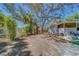 Large backyard showcasing mature trees, partial fencing, and the home's rear exterior with porch at 2340 Kingston S St, St Petersburg, FL 33711