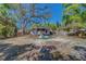 Spacious backyard with mature trees, partial fencing, and a glimpse of the home's rear exterior at 2340 Kingston S St, St Petersburg, FL 33711