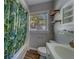 Well lit bathroom with decorative shower curtain and shelves next to the window at 2340 Kingston S St, St Petersburg, FL 33711