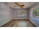 This spacious bedroom includes new flooring, two large windows, and a ceiling fan at 2340 Kingston S St, St Petersburg, FL 33711
