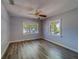 The spacious bedroom with two large windows has beautiful, newly installed flooring and a modern ceiling fan at 2340 Kingston S St, St Petersburg, FL 33711