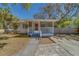 Charming one-story home featuring a screened front porch with a red door at 2340 Kingston S St, St Petersburg, FL 33711