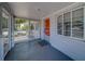Inviting screened front porch with white railing, neutral paint, and red door at 2340 Kingston S St, St Petersburg, FL 33711