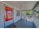 Front porch showcasing a screened-in area with a red front door and neutral accents at 2340 Kingston S St, St Petersburg, FL 33711