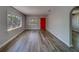 Bright living room features new light-colored wood-look flooring and a red front door at 2340 Kingston S St, St Petersburg, FL 33711