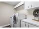 Functional laundry room with a white washer and dryer and ample storage at 2600 W Vina Del Mar Blvd, St Pete Beach, FL 33706