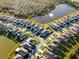 Aerial view of neighborhood with several homes surrounding pond with a fountain at 3097 Storybrook Preserve Dr, Odessa, FL 33556