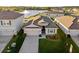 Aerial view of a single-Gathering home on a landscaped lot with a lake view and close proximity to neighboring homes at 3097 Storybrook Preserve Dr, Odessa, FL 33556