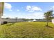 Large backyard with green grass, white fence, view of the pond, and beautiful landscaping at 3097 Storybrook Preserve Dr, Odessa, FL 33556