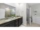 Beautiful bathroom featuring double vanity with granite counters, modern sinks, and a large mirror at 3097 Storybrook Preserve Dr, Odessa, FL 33556