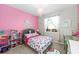 Charming pink bedroom features colorful bedding, large window with curtains, and fun decor at 3097 Storybrook Preserve Dr, Odessa, FL 33556