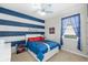 Fun bedroom featuring a blue striped accent wall, Spiderman themed decor and ceiling fan at 3097 Storybrook Preserve Dr, Odessa, FL 33556