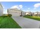 View of house with long driveway, attached two car garage and well-manicured lawn at 3097 Storybrook Preserve Dr, Odessa, FL 33556