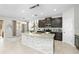 Open-concept kitchen featuring dark cabinets, granite countertops, and a large center island with a tile backsplash at 3097 Storybrook Preserve Dr, Odessa, FL 33556