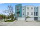 Modern townhome with a light teal and white exterior, featuring a two-car garage and manicured landscaping at 3405 W Swann Ave # 9, Tampa, FL 33609