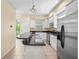 Sunlit kitchen with white cabinets, stainless steel appliances, and an island breakfast bar at 3405 W Swann Ave # 9, Tampa, FL 33609