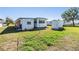 Exterior shot of a cozy home with a well-maintained lawn, shed, and ample space at 37235 Cora Ave, Zephyrhills, FL 33542