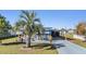 Well-maintained single-story home with mature landscaping, patio, and carport at 37235 Cora Ave, Zephyrhills, FL 33542