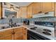 Well-lit kitchen featuring wood cabinets, modern appliances, and double basin sink at 37235 Cora Ave, Zephyrhills, FL 33542