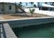Tranquil backyard space near the water, featuring a retaining wall and lush landscaping at 390 Belle Point Dr, St Pete Beach, FL 33706