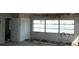 Condemned living room featuring exterior views through a multi-pane window with structural damage to the walls and ceiling at 390 Belle Point Dr, St Pete Beach, FL 33706
