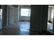 Damaged living room with tile flooring, featuring an exterior view through a multi-pane window, and damaged walls and ceiling at 390 Belle Point Dr, St Pete Beach, FL 33706