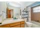Bathroom with neutral tones, tub, and decorative shelving for towels and bathroom supplies at 440 Pendleton Dr, Venice, FL 34292