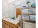 Bathroom features large mirror and plentiful shelving, neutral tones, and sink basin at 440 Pendleton Dr, Venice, FL 34292