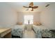 Well-lit bedroom with twin beds, tile floors, and a decorative ceiling fan at 440 Pendleton Dr, Venice, FL 34292