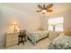 Bright bedroom featuring two twin beds, tile floors, and a decorative ceiling fan at 440 Pendleton Dr, Venice, FL 34292