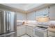 Bright kitchen with stainless steel fridge and white appliances, cabinets, and countertops at 440 Pendleton Dr, Venice, FL 34292