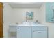 Well-lit laundry room with both washer and dryer, as well as utility sink at 440 Pendleton Dr, Venice, FL 34292