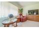 Cozy living room featuring a comfortable recliner, display cabinet, and a window with natural light at 440 Pendleton Dr, Venice, FL 34292