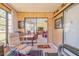 Bright sunroom featuring sliding glass doors, wood paneling, and comfortable seating with views at 440 Pendleton Dr, Venice, FL 34292