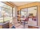 Bright sunroom featuring sliding glass doors, wood paneling, and views to the outside at 440 Pendleton Dr, Venice, FL 34292