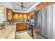 A well-lit kitchen with light-toned wood cabinets, tiled floor, and stainless steel appliances at 5220 Brittany S Dr # 1403, St Petersburg, FL 33715