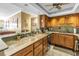Bright kitchen featuring wood cabinets, tile backsplash, and marble countertops with breakfast bar at 5220 Brittany S Dr # 1403, St Petersburg, FL 33715